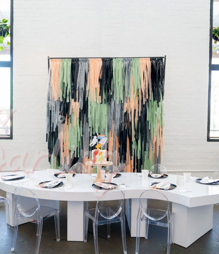 Outer Space themed orange, green, and black fringe party backdrop and balloon garland for boy's birthday by Oh My Darling Party Co