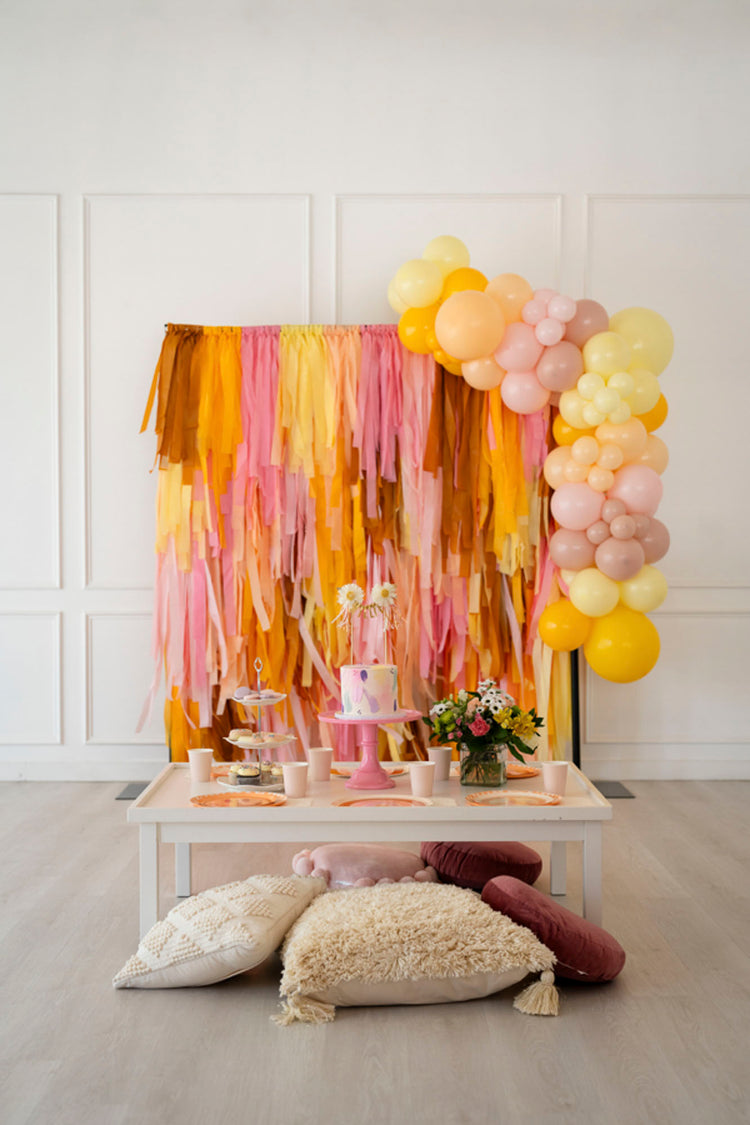 Oh My Darling Party Co yellow, pink, and brown fringe backdrop and balloon garland