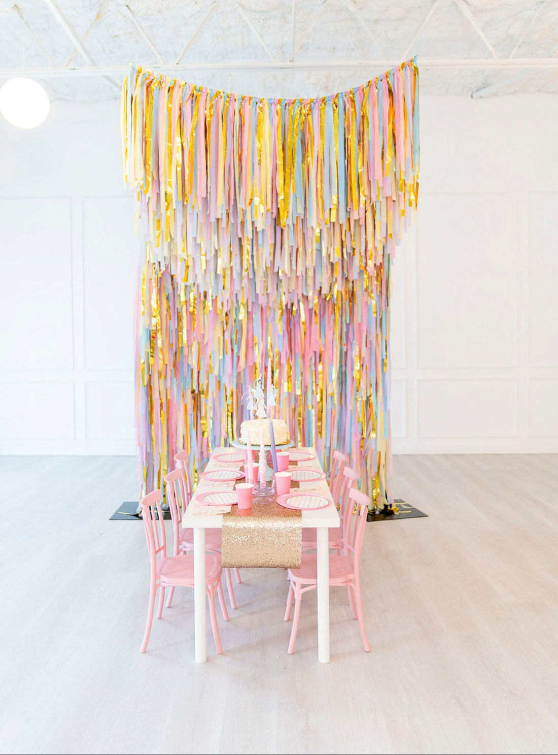 Pastel pink and yellow fringe backdrop and aerial party installation by Oh My Darling Party Co