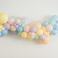 Pastel Balloon Kit fringe garland hanging against a white wall with balloons. Fringe decor perfect for corporate events or parties.