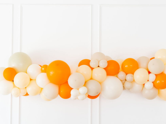 Cutie Balloon Kit fringe garland hanging against a white wall with balloons. Fringe decor perfect for corporate events or parties.