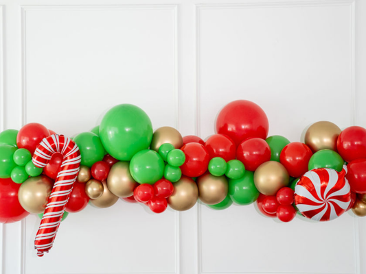 Cup of Cheer Balloon Kit fringe garland hanging against a white wall with balloons. Fringe decor perfect for corporate events or parties.