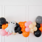 Ghouls Wanna Have Fun Balloon Kit fringe garland hanging against a white wall with balloons. Fringe decor perfect for corporate events or parties.