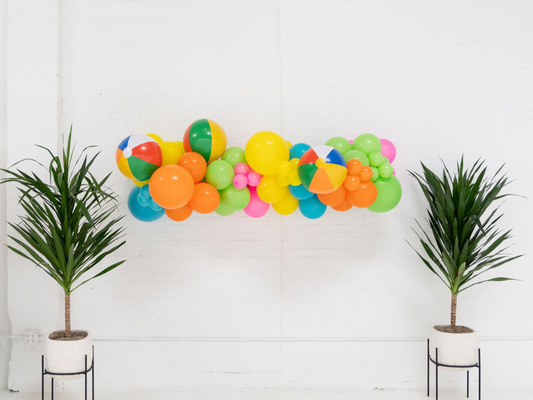 Beach Days Balloon Kit fringe garland hanging against a white wall with balloons. Fringe decor perfect for corporate events or parties.