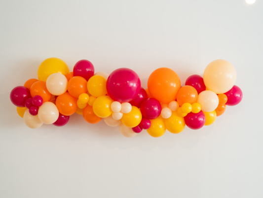 Dazed & Engaged Balloon Kit fringe garland hanging against a white wall with balloons. Fringe decor perfect for corporate events or parties.