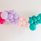 Pop Star Balloon Kit fringe garland hanging against a white wall with balloons. Fringe decor perfect for corporate events or parties.