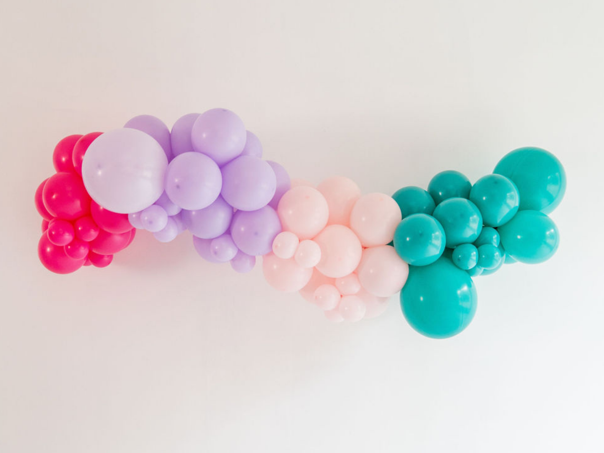 Pop Star Balloon Kit fringe garland hanging against a white wall with balloons. Fringe decor perfect for corporate events or parties.