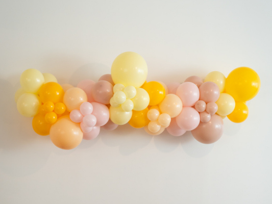 Too Groovy Balloon Kit fringe garland hanging against a white wall with balloons. Fringe decor perfect for corporate events or parties.