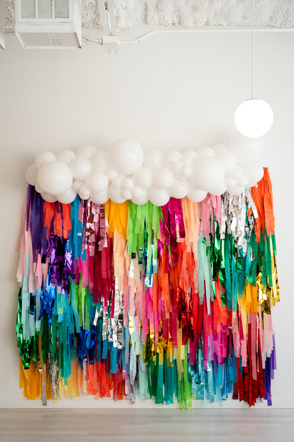 Oh My Darling Party Co rainbow fringe backdrop with white ballon garland