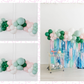 Pinkmas Balloon Kit fringe garland hanging against a white wall with balloons. Fringe decor perfect for corporate events or parties.