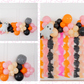 Ghouls Wanna Have Fun Balloon Kit fringe garland hanging against a white wall with balloons. Fringe decor perfect for corporate events or parties.