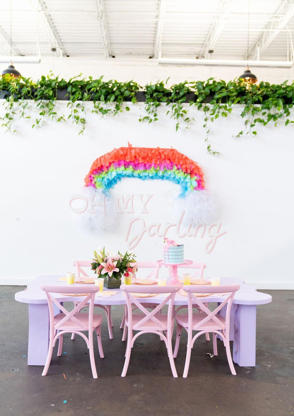 Chasing Rainbows Shape Backdrop fringe garland hanging against a white wall with balloons. Fringe decor perfect for corporate events or parties.
