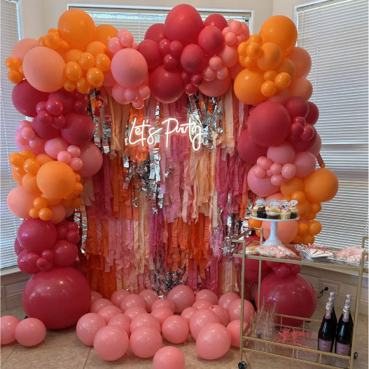 Oh my darling party co customer photo of pink and orange fringe backdrop and balloon garland