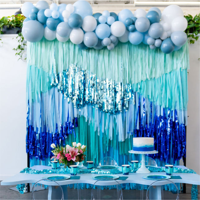 Underwater blue and white fringe backdrop and balloon garland for birthday party by Oh My Darling Party Co