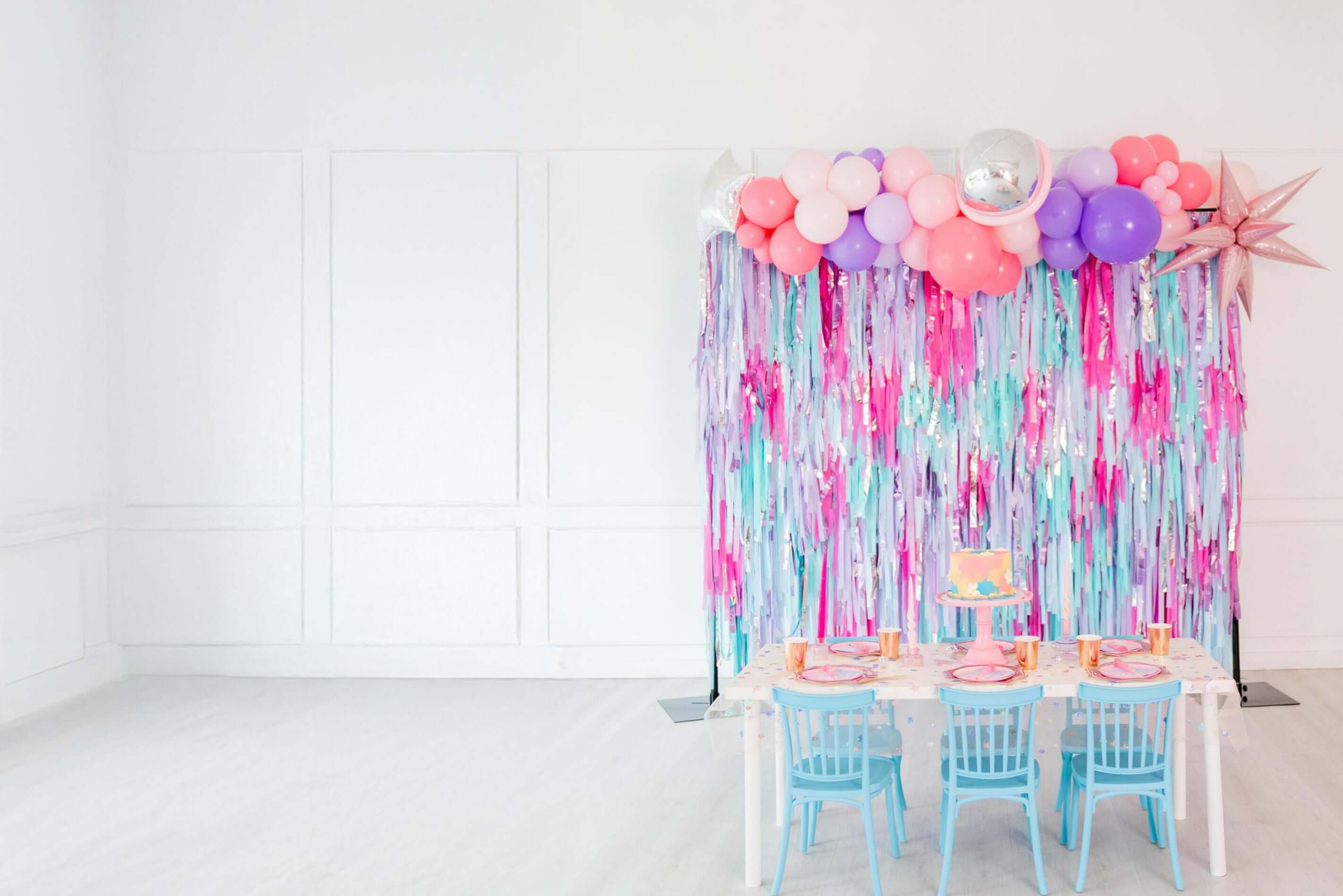 Oh My Darling Party Co purple, pink, and blue fringe backdrop with balloons and party table