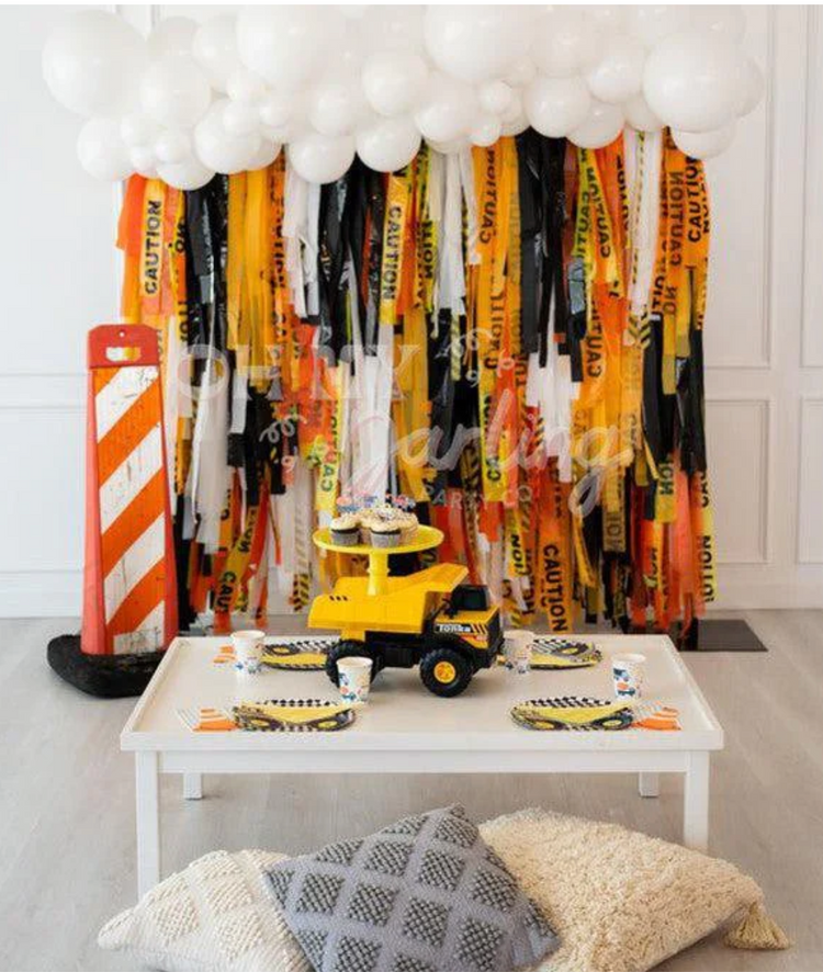 Construction themed fringe party backdrop and balloon garland for boy's birthday by Oh My Darling Party Co