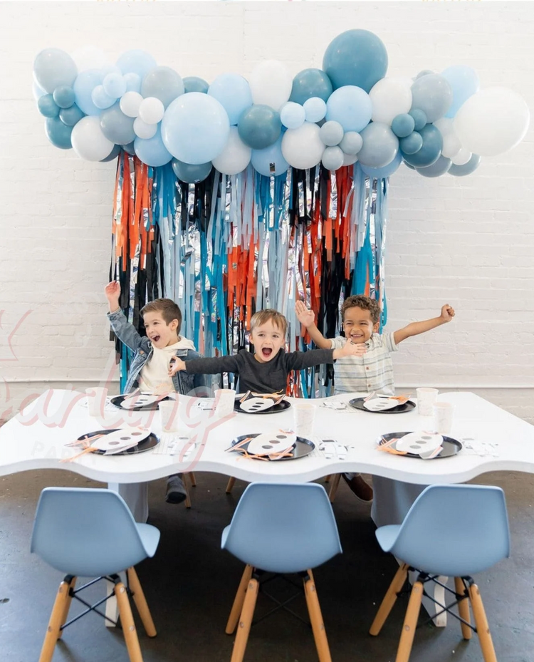 Blue and orange fringe party backdrop and balloon garland for boy's birthday by Oh My Darling Party Co 