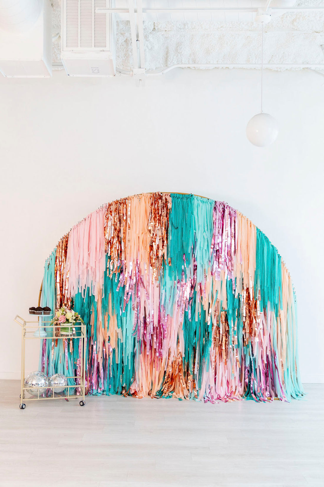 Turquoise and pink semi circle fringe backdrop by Oh My Darling Party Co