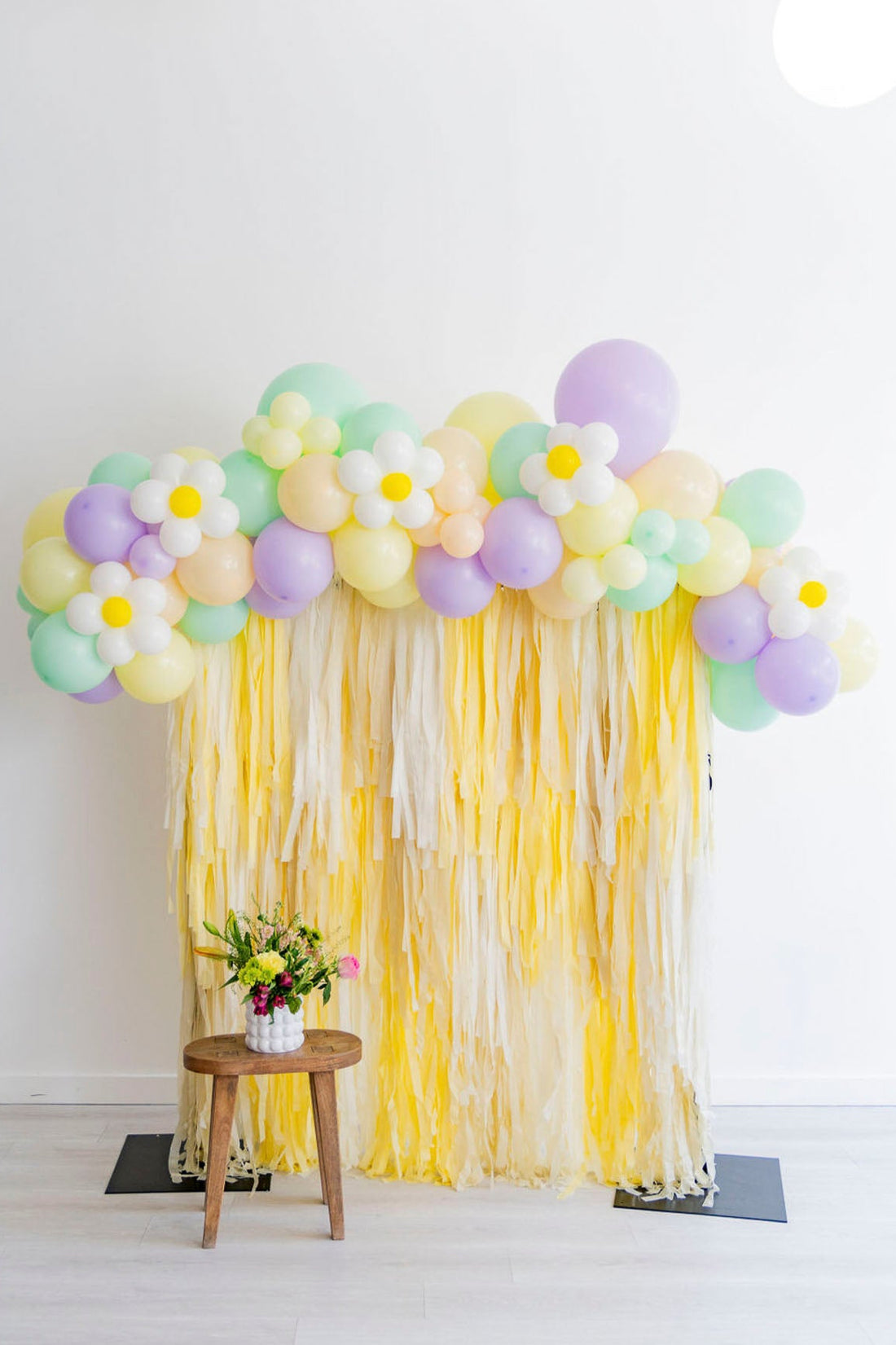Yellow pastel fringe backdrop and balloon garland by Oh My Darling Party Co