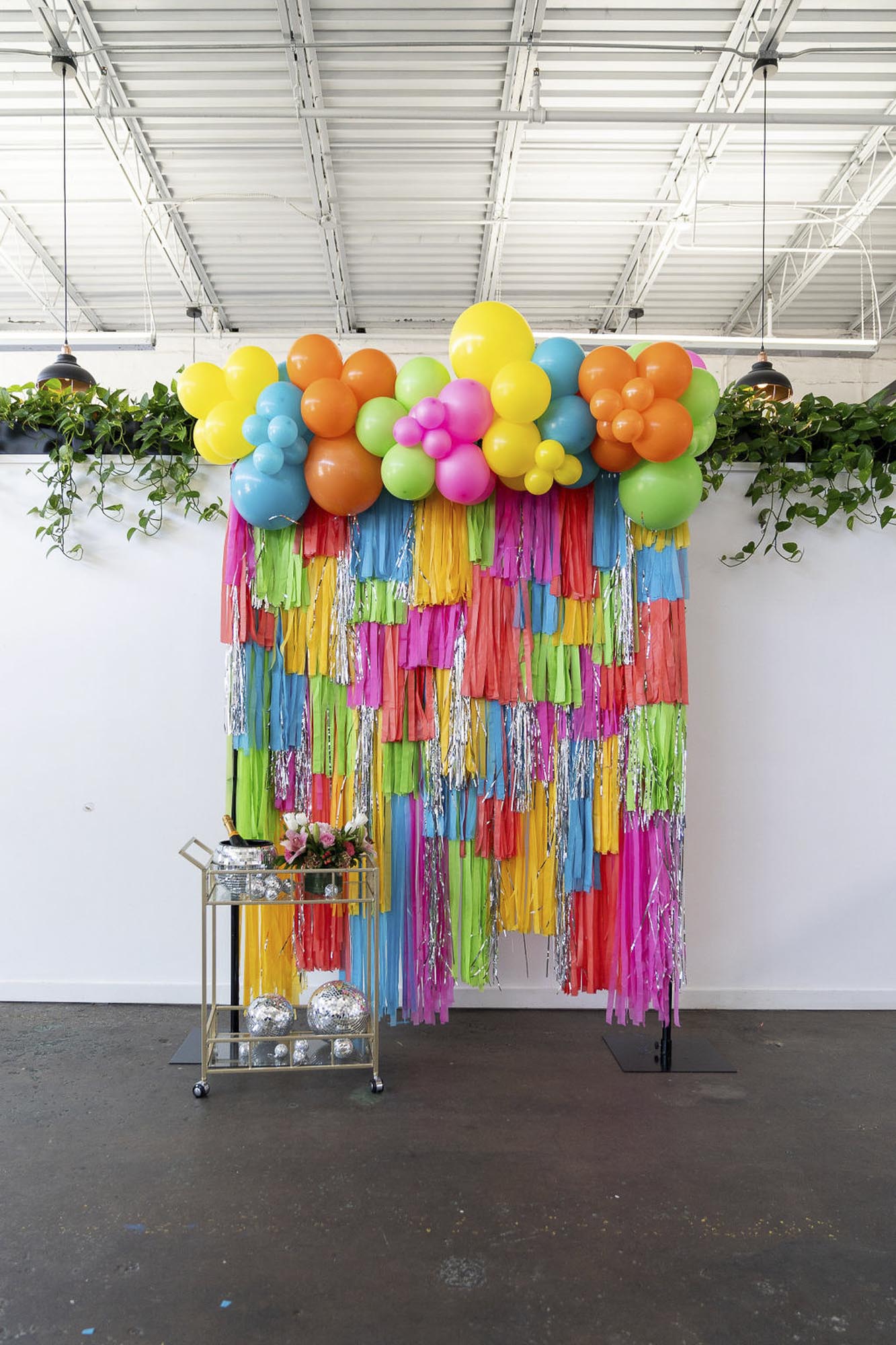 Neon multicolor fringe backdrop and balloon garland by Oh My Darling Party Co